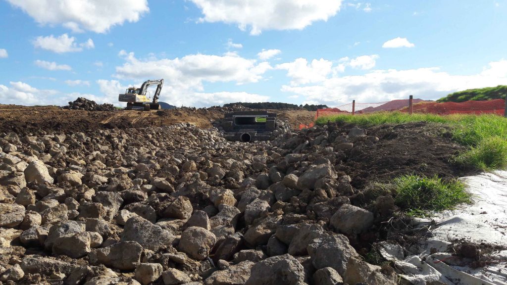 digger next to stones dam outlet