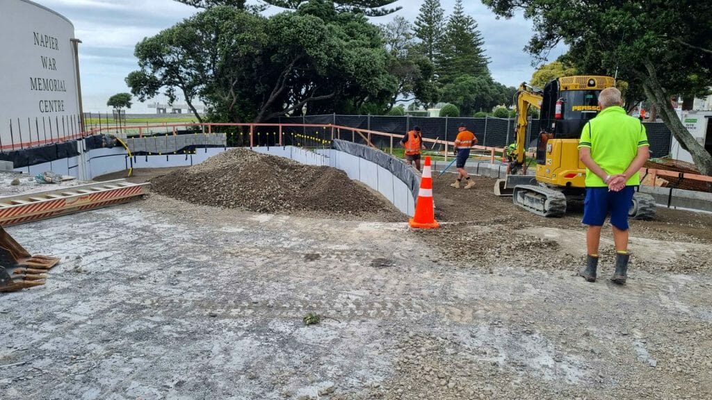 A construction site with a digger and people